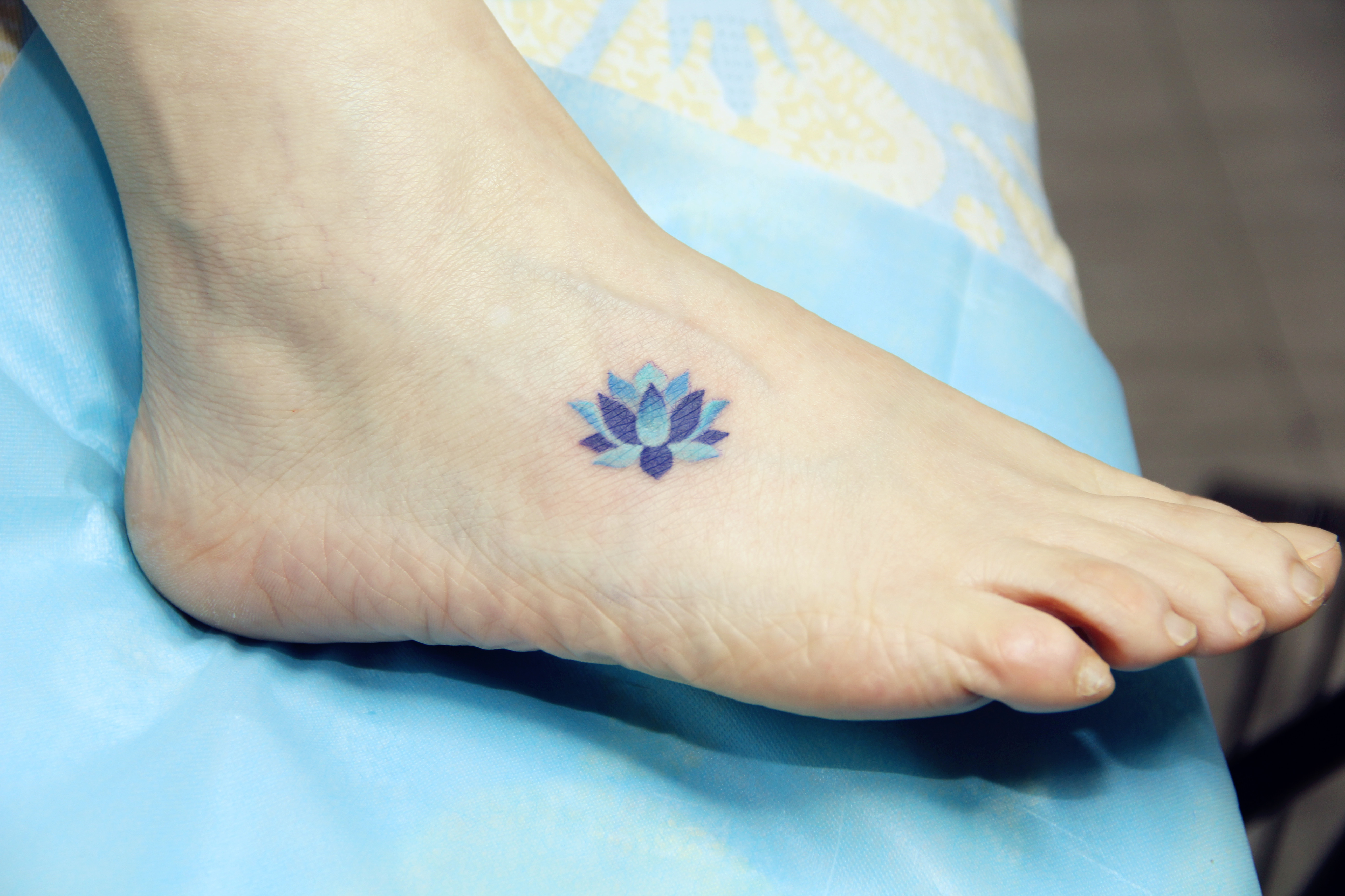 董小姐在脚背处纹刻的精致蓝莲花纹身图案