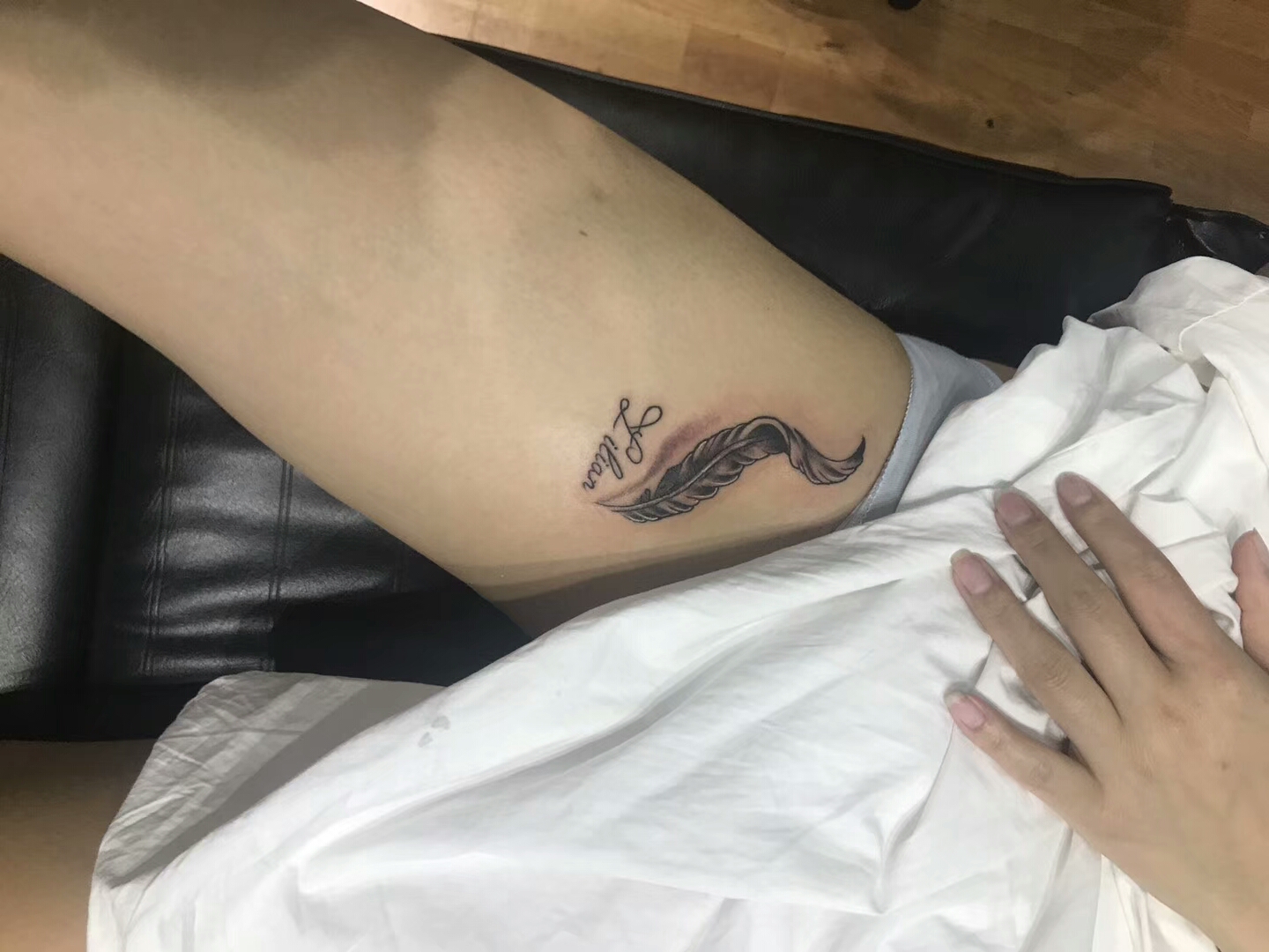苗条的孙小姐大腿处的轻盈羽毛纹身图案